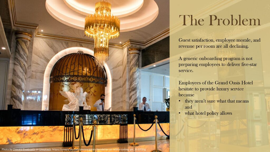 Powerpoint slide of hotel desk with text: The Problem Guest satisfaction, employee morale, and revenue per room are all declining. A generic onboarding program is not preparing employees to deliver five-star service. Employees of the Grand Oasis Hotel hesitate to provide luxury service because they aren’t sure what that means and what hotel policy allows.