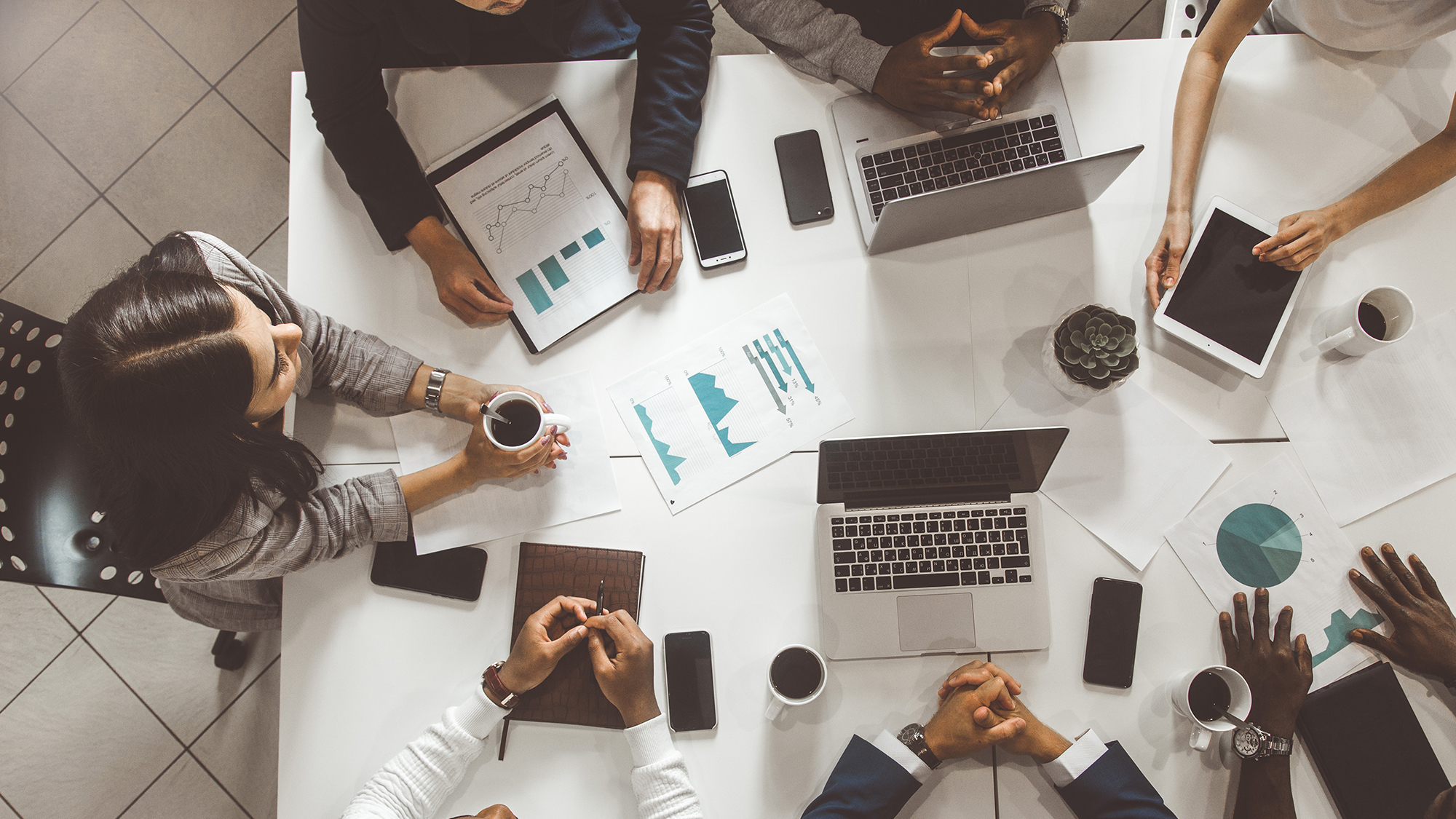 top view work workplace. A team of young office workers, businessmen with laptop working at the table, communicating together in an office. Corporate businessteam and manager in a meeting. coworking.